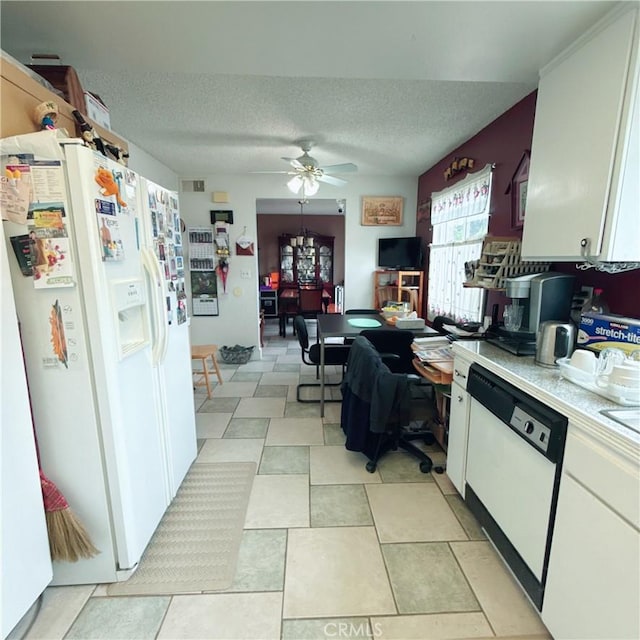 kitchen with white cabinetry, a textured ceiling, and white appliances