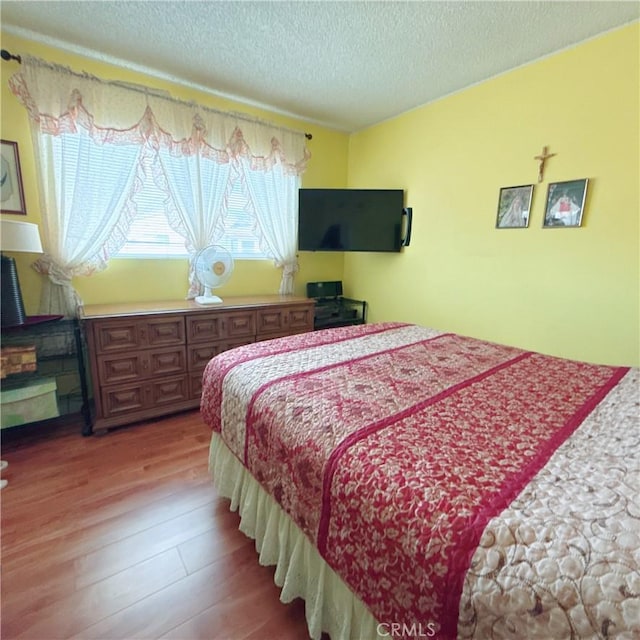 bedroom with wood-type flooring and a textured ceiling