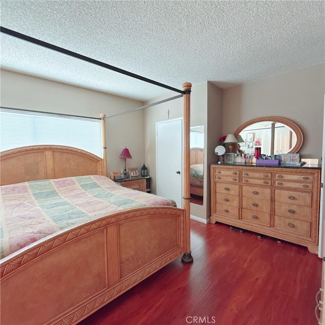 bedroom featuring dark hardwood / wood-style flooring and a textured ceiling