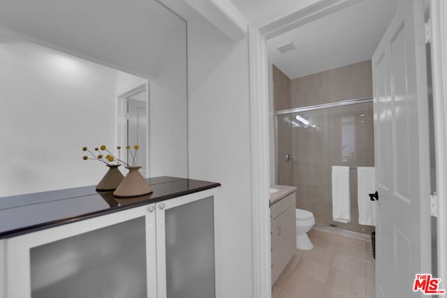 bathroom with vanity, an enclosed shower, and toilet