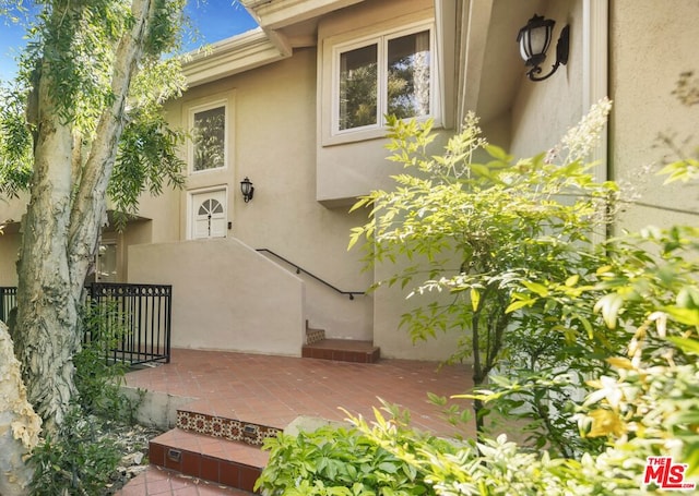 view of exterior entry featuring a patio area