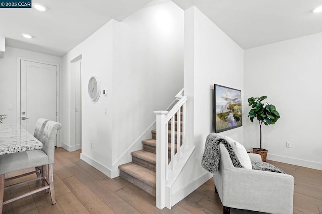 stairway with hardwood / wood-style floors