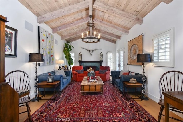 living area featuring lofted ceiling with beams, hardwood / wood-style floors, wooden ceiling, and a chandelier