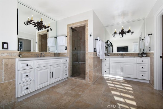 bathroom featuring a chandelier, vanity, an enclosed shower, and tile walls