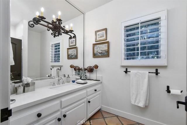 bathroom with tile patterned flooring, vanity, and an inviting chandelier