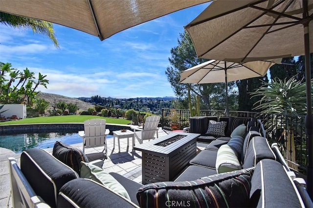 view of patio / terrace featuring a fenced in pool and an outdoor living space with a fire pit