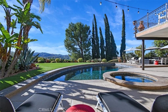 view of pool with a mountain view, a patio, and an in ground hot tub