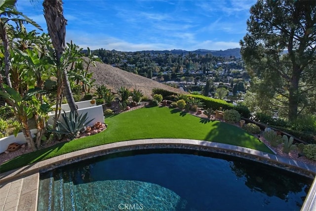 view of swimming pool featuring a mountain view and a lawn