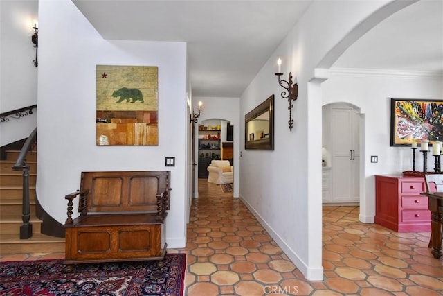 hall featuring light tile patterned floors and ornamental molding