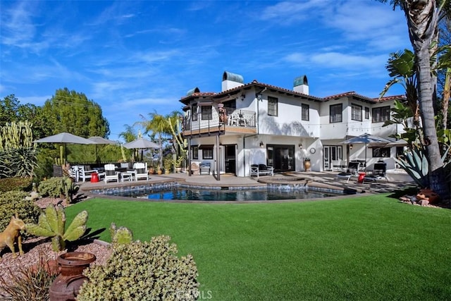 back of property featuring a lawn, a patio, and a balcony