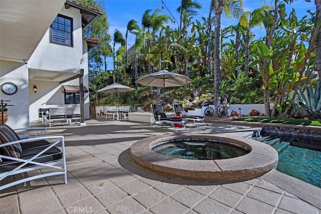 view of patio / terrace with a pool with hot tub