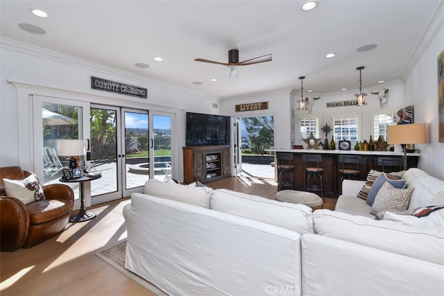 living room with crown molding, a healthy amount of sunlight, and hardwood / wood-style floors