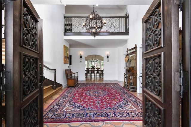 entryway featuring a towering ceiling and an inviting chandelier