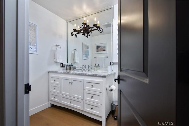 bathroom featuring vanity, wood-type flooring, and toilet