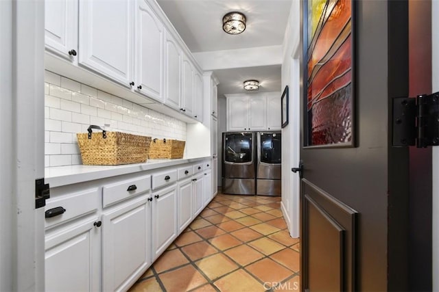 laundry area featuring light tile patterned floors, cabinets, and washing machine and clothes dryer