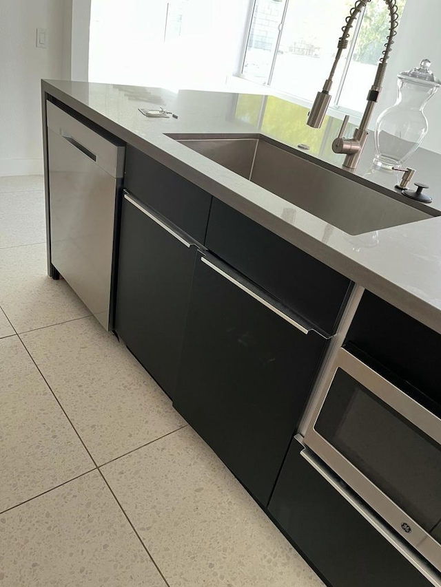 kitchen featuring sink, light tile patterned floors, and dishwasher