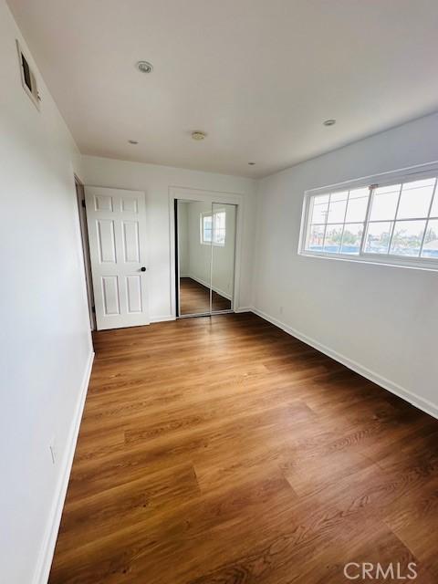 unfurnished bedroom featuring hardwood / wood-style floors and a closet