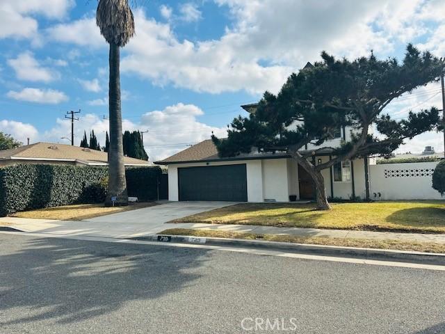 single story home featuring a garage and a front yard