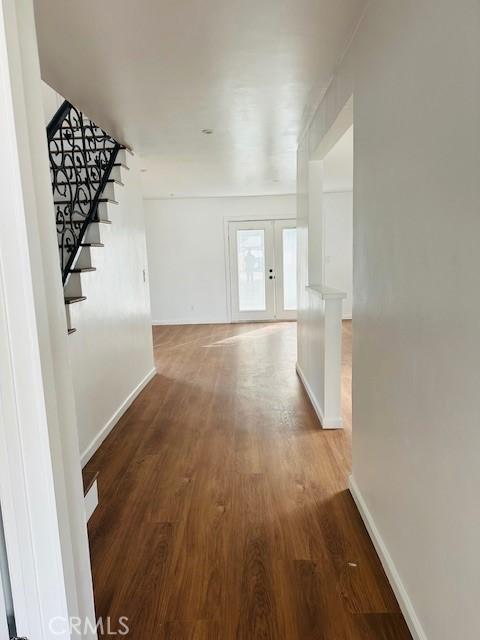 corridor featuring french doors and wood-type flooring