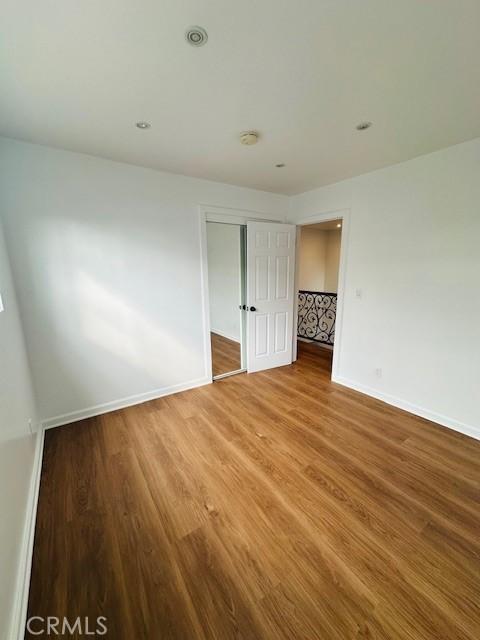 unfurnished bedroom with hardwood / wood-style floors and a closet