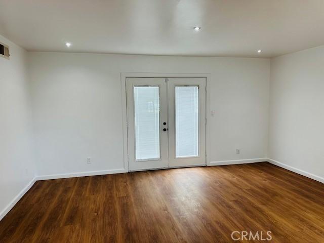 spare room featuring dark hardwood / wood-style floors and french doors