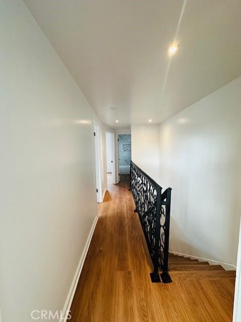 corridor with hardwood / wood-style flooring