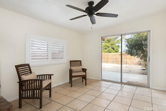 living area with ceiling fan and light tile patterned floors