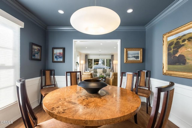 dining space with wood-type flooring and crown molding