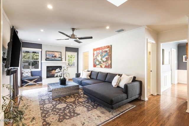 living room with hardwood / wood-style floors, ornamental molding, a healthy amount of sunlight, and ceiling fan