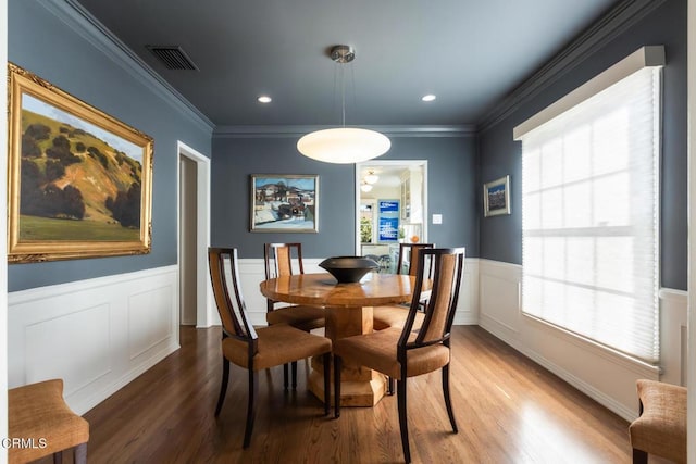 dining space featuring crown molding and wood-type flooring