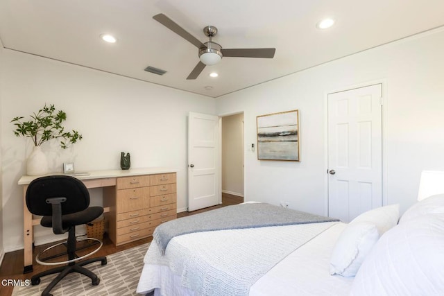 bedroom with hardwood / wood-style flooring, built in desk, and ceiling fan