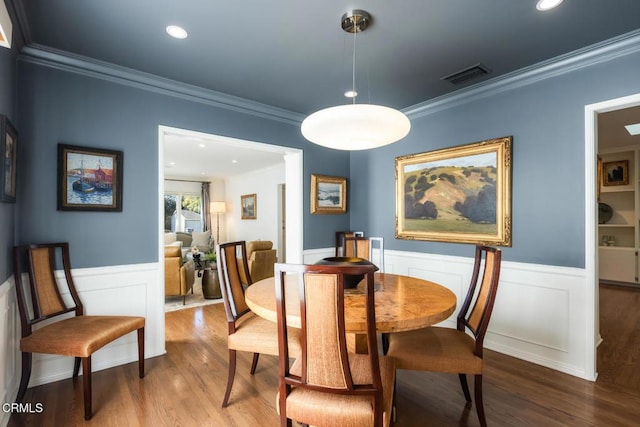 dining area with hardwood / wood-style floors and ornamental molding