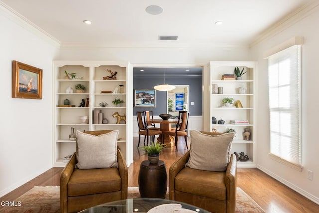 living area featuring crown molding and hardwood / wood-style floors