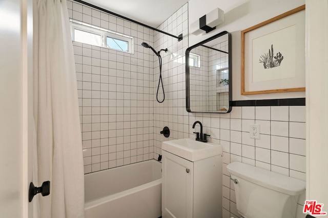 full bathroom with vanity, tile walls, shower / tub combo, and toilet