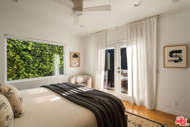 bedroom featuring multiple windows, hardwood / wood-style floors, and ceiling fan