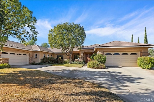 ranch-style house featuring a garage and a front lawn