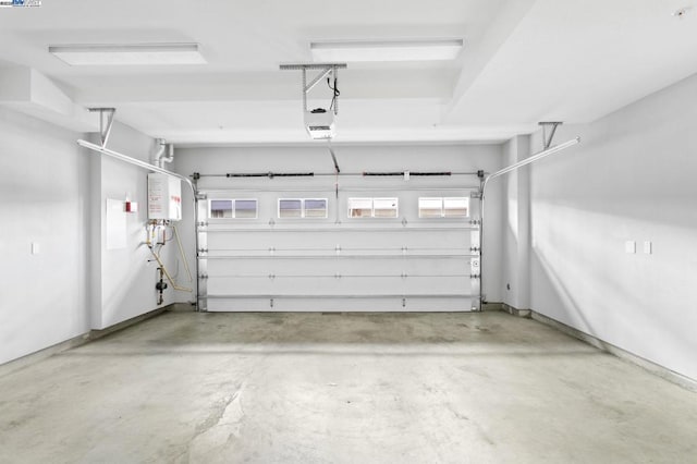 garage featuring a garage door opener and tankless water heater