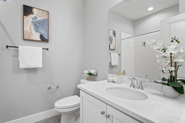 bathroom featuring vanity, toilet, and a shower