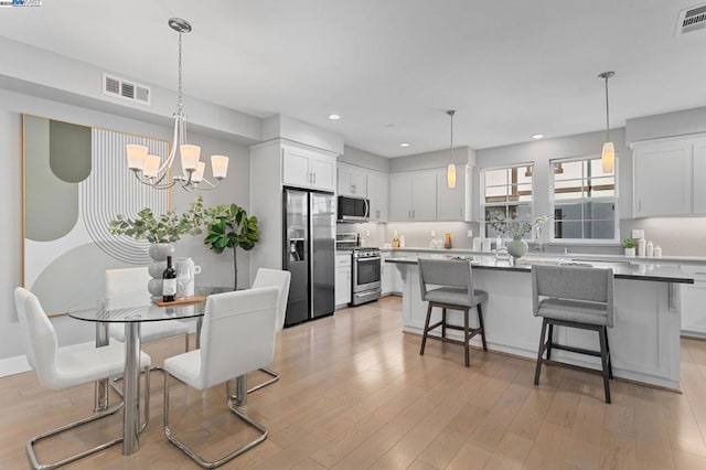 dining area with a chandelier and light hardwood / wood-style flooring