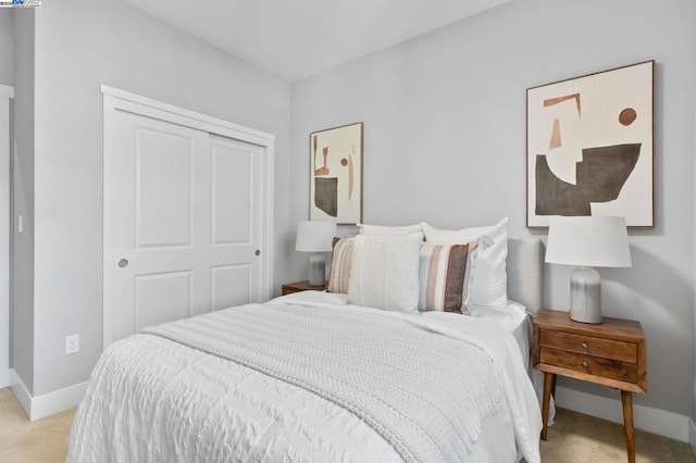 bedroom with light colored carpet and a closet