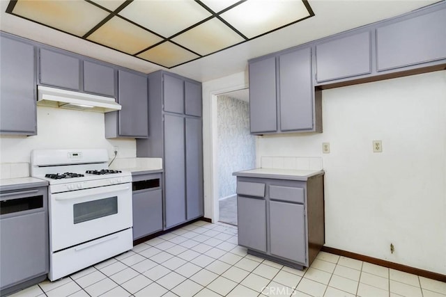 kitchen featuring gray cabinetry, light tile patterned floors, and white gas range oven