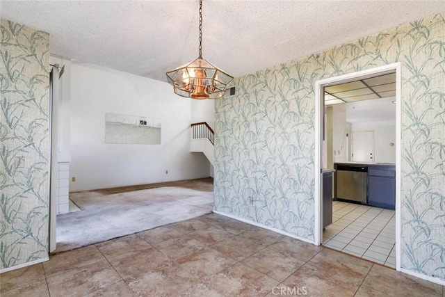 unfurnished dining area with light colored carpet and a textured ceiling