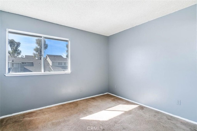 carpeted spare room featuring a textured ceiling