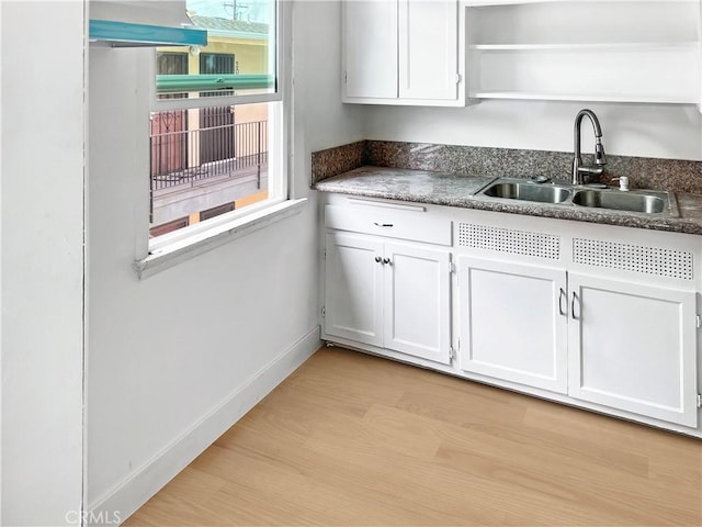 kitchen featuring sink, white cabinets, and light hardwood / wood-style flooring