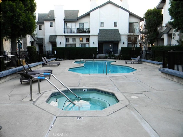 view of pool with a community hot tub and a patio