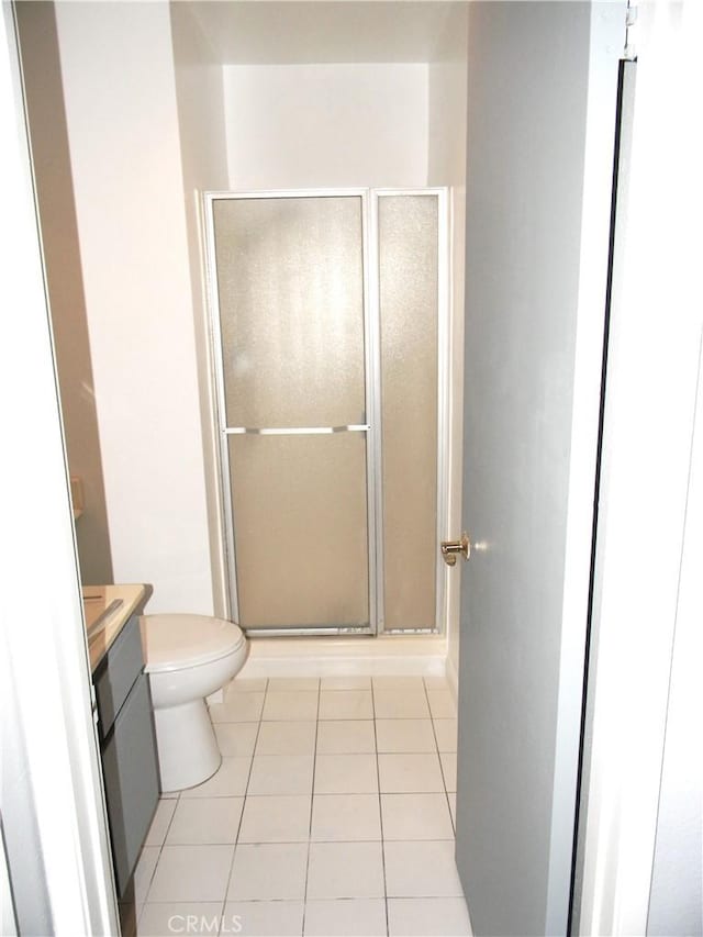 bathroom featuring walk in shower, tile patterned floors, vanity, and toilet