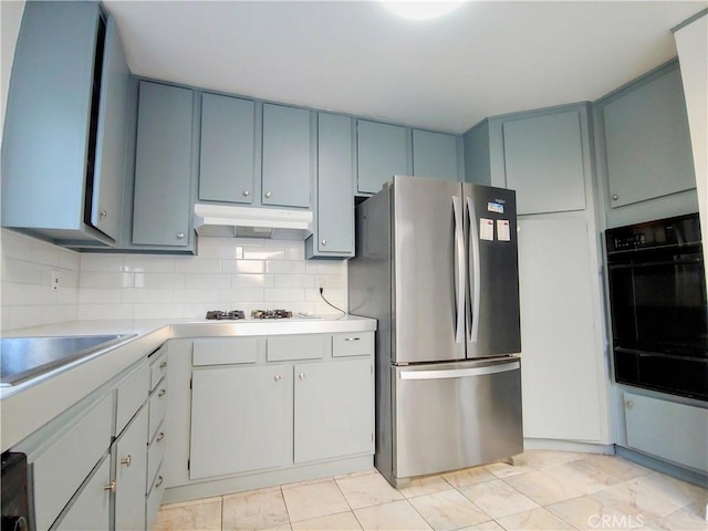 kitchen featuring sink, white gas cooktop, stainless steel refrigerator, double oven, and decorative backsplash