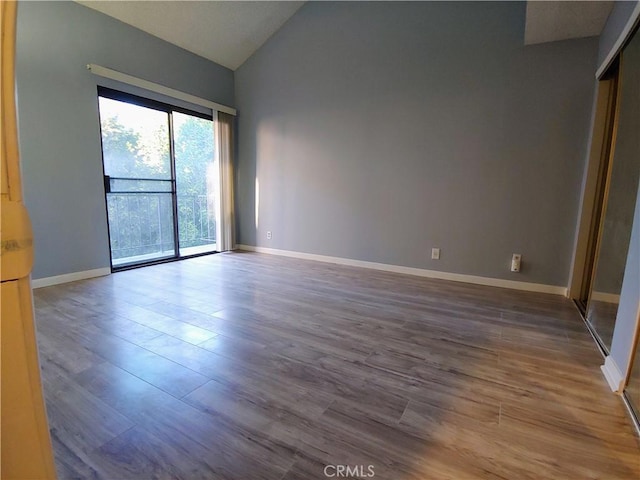 unfurnished room with vaulted ceiling and hardwood / wood-style floors