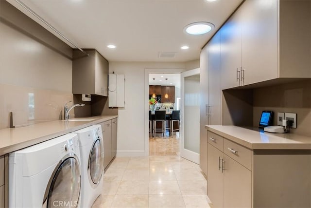 laundry room featuring cabinets, sink, light tile patterned floors, and independent washer and dryer