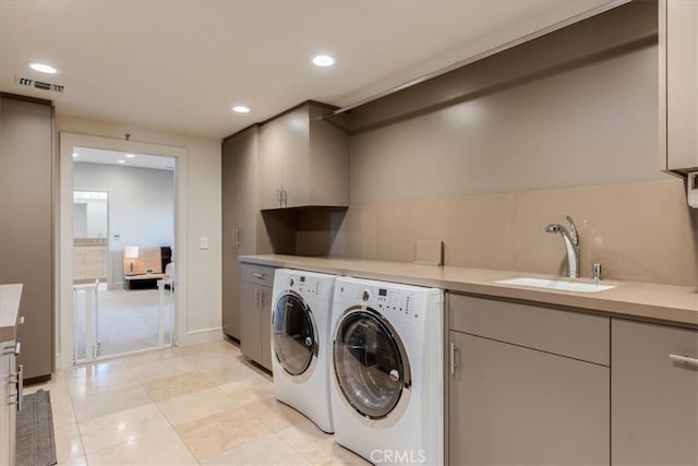 laundry area with cabinets, sink, light tile patterned floors, and washer and clothes dryer